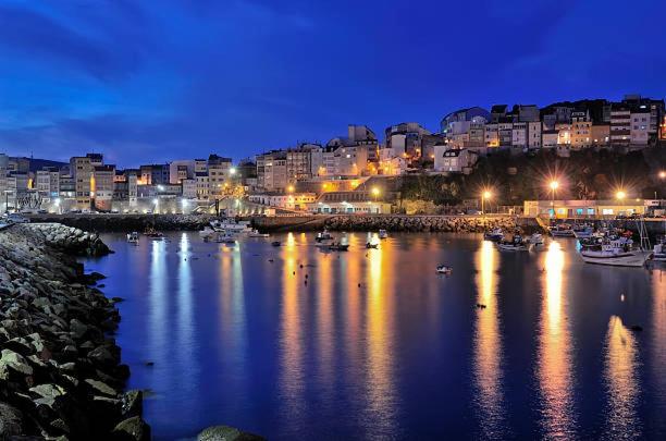 a harbor at night with boats in the water at Casa Atalaya en Malpica in Malpica