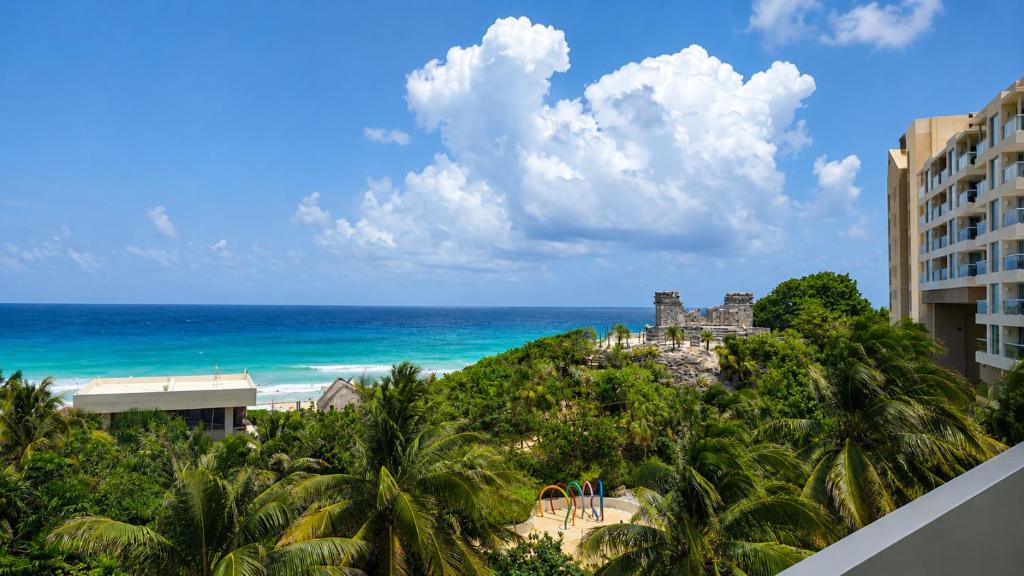 a view of the ocean from the balcony of a resort at Beachfront Getaway Condo in Cancún