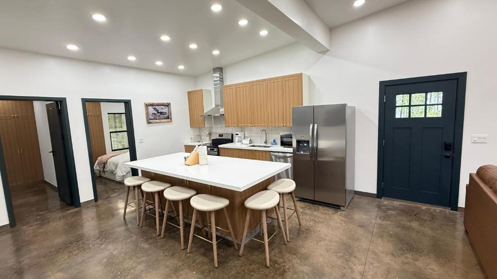 a kitchen with a large white island in a room at Glacier Luxury Retreat Oak Tree Apartment 3 in Hungry Horse