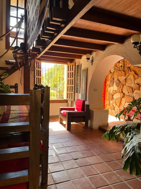 a living room with a couch and a stone wall at Casa Alquimia Completa in Samaipata