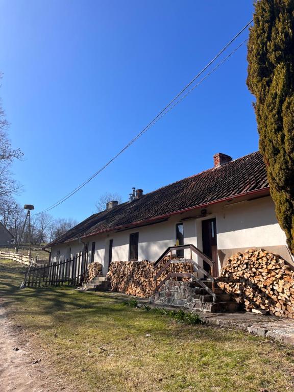 a house with a pile of logs in front of it at Pokój i Spokój in Szarki