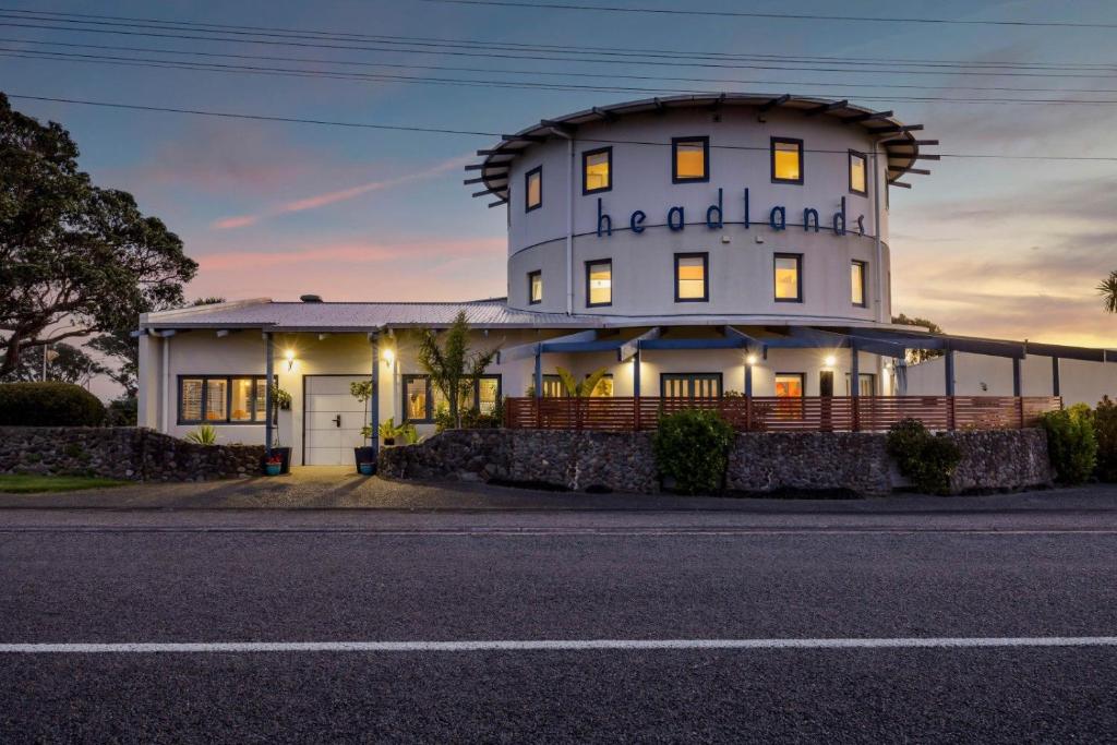 a white building with a sign on the side of it at Headlands Hotel in Opunake