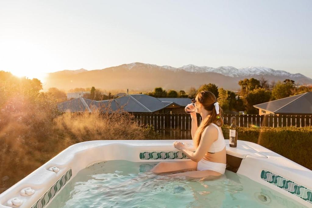 a woman sitting in a jacuzzi tub at Handy to Town, Spacious, Relaxed - KK14905 in Kaikoura