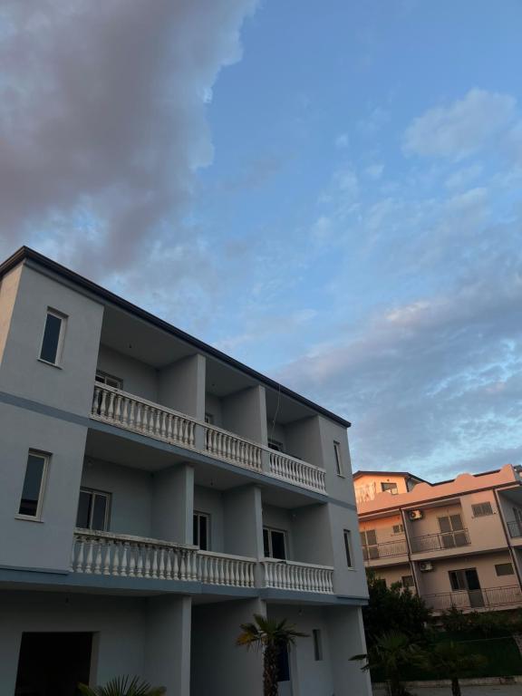 a white apartment building with a balcony at Infinity room in Velipojë