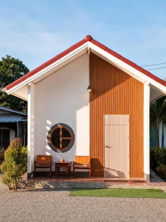 a small building with a bench and a door at DD HOMESTAy หาดสะพลี in Ban Tha Samet (1)