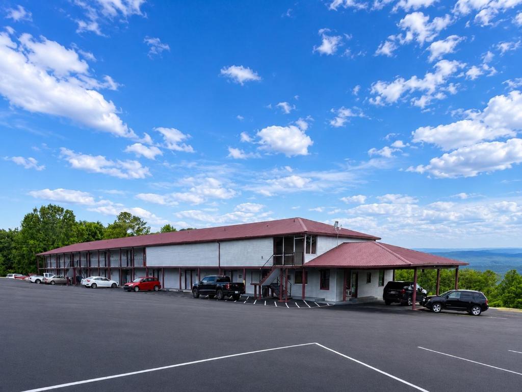 a building with cars parked in a parking lot at Overlook Mountain Inn in Guntersville