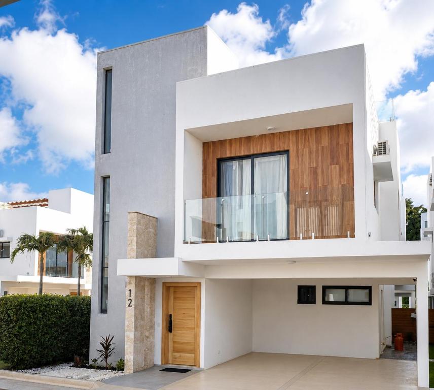 a white house with a wooden door at Modern Villa 2 BR Near Airport, Beaches, Dining in Punta Cana