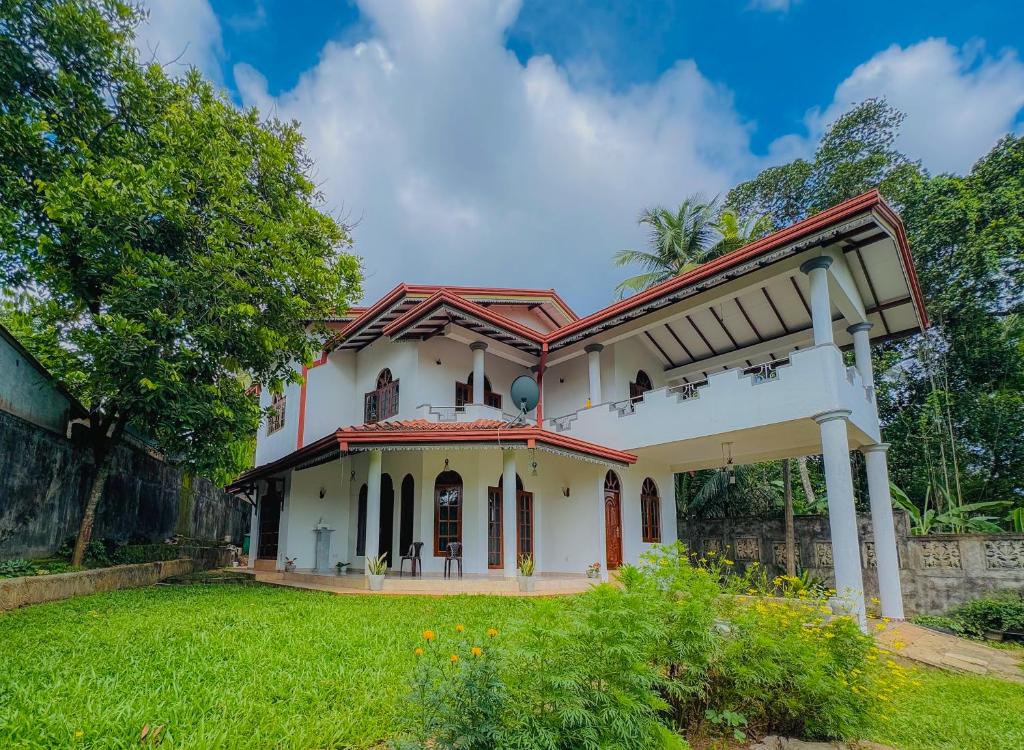 a white house with a red roof at Senu Bungalow in Ragama
