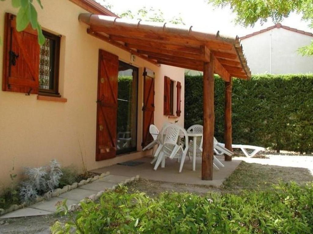 a patio with a table and chairs under a pergola at Maison avec animaux admis - 4 pers. - API-1-52-2864 in Saint-Rome-de-Tarn