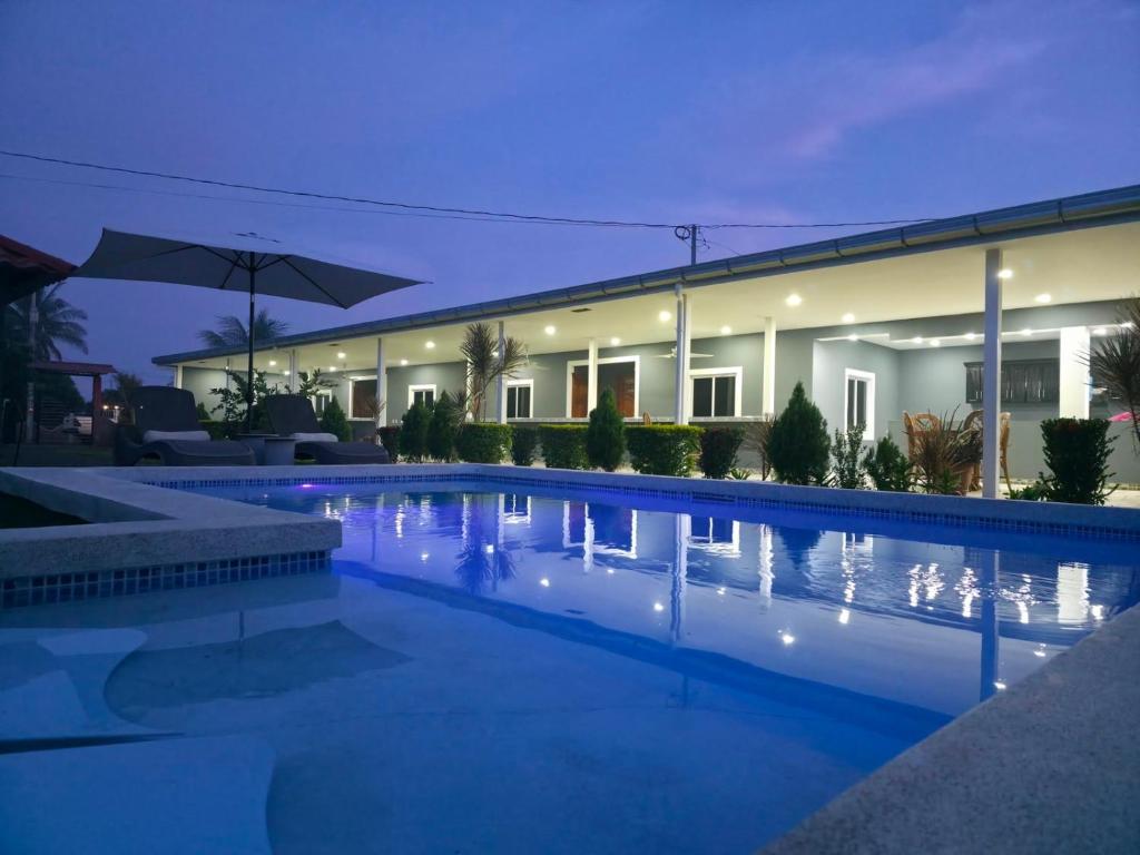 a swimming pool in front of a house at night at Lodge Ayla Punta Mango in Jucuarán
