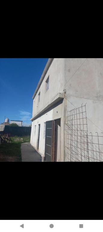 a large white building with a door and a gate at Duplex con cochera in Paraná