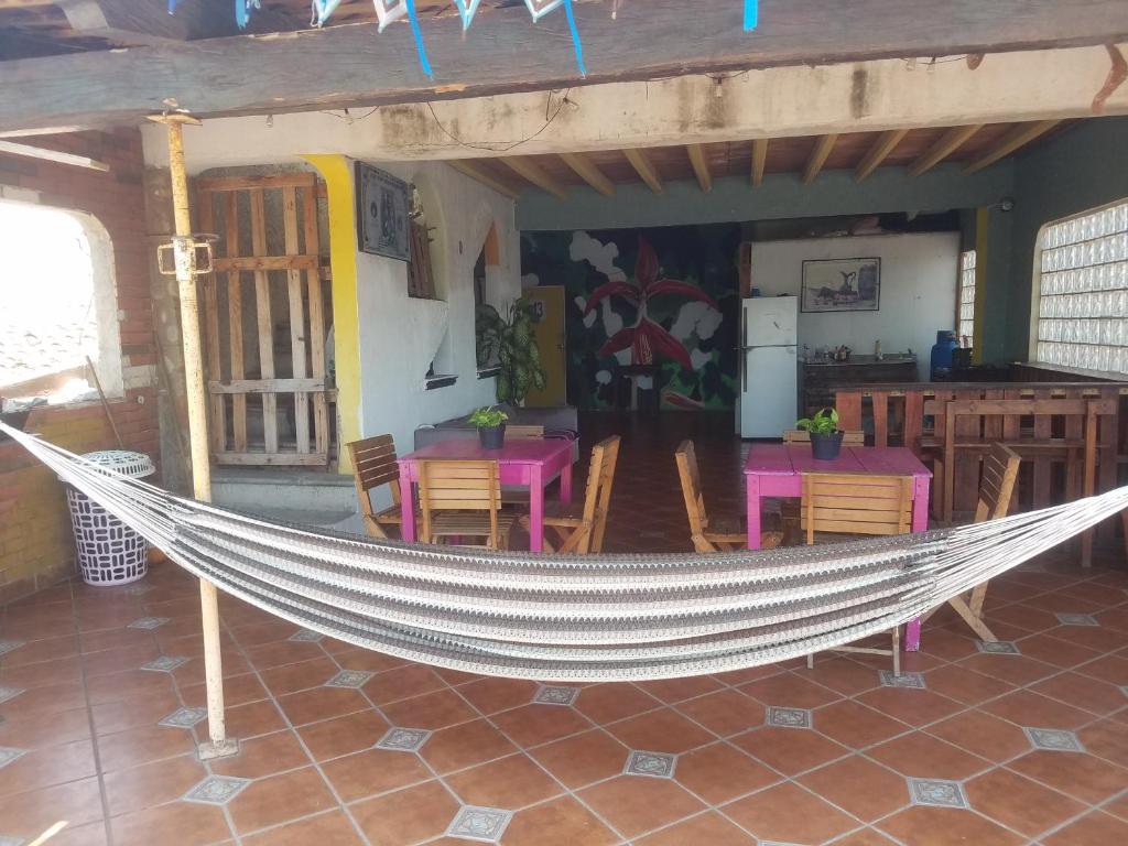 a hammock in a room with tables and chairs at hostal la playa vallarta in Puerto Vallarta