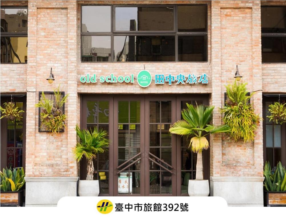 an old school building with palm trees in front of it at Central Land Hotel in Taichung