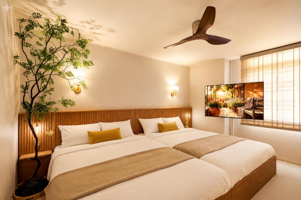 a bedroom with a large bed and a ceiling fan at 잠실 트리하우스 KSPO돔 인근 Lotte World in Seoul
