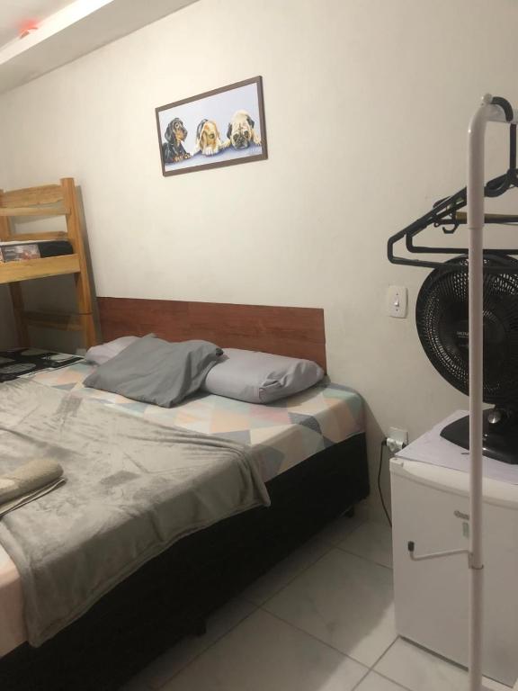 a small bedroom with a bed and a shelf at Pousada da Neném - Quarto Tangerina in Campina Grande