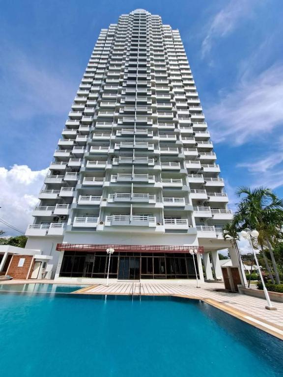 a tall building with a pool in front of it at New world condo1802 in Rayong