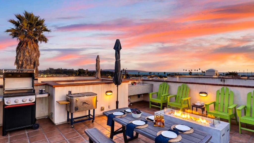 a rooftop patio with a grill and a table and chairs at Stimson Coastal Luxury by AvantStay in Pismo Beach