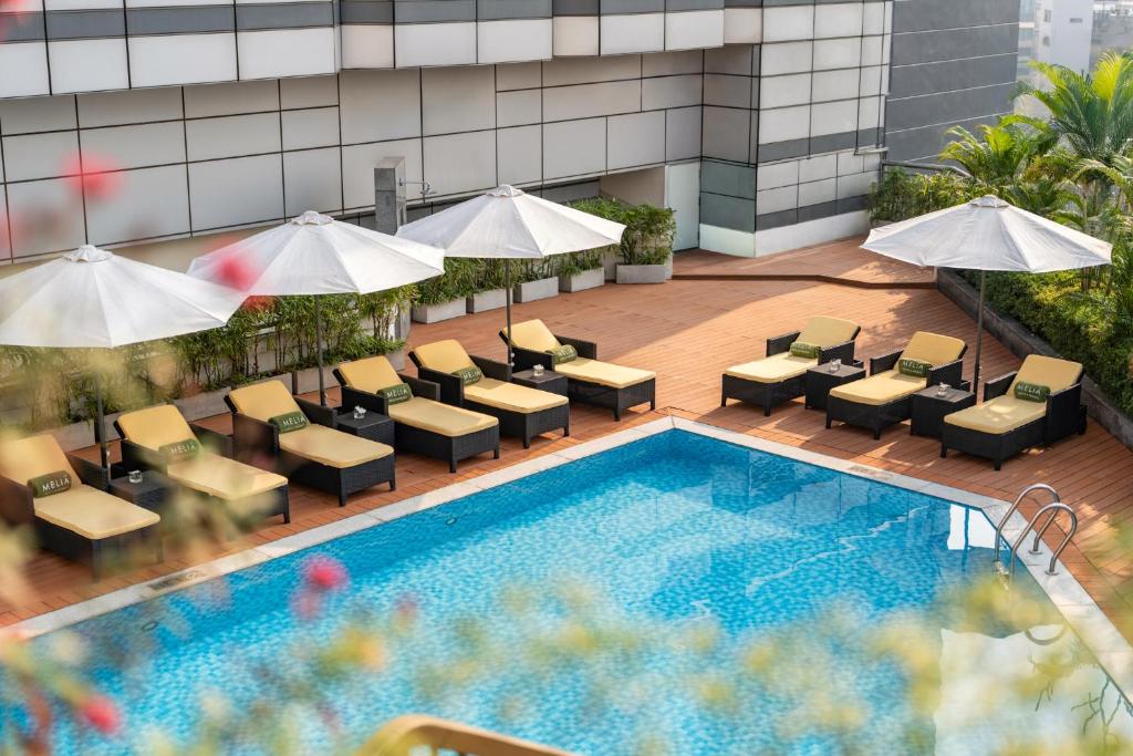 an overhead view of a hotel pool with chairs and umbrellas at Meliá Hanoi in Hanoi