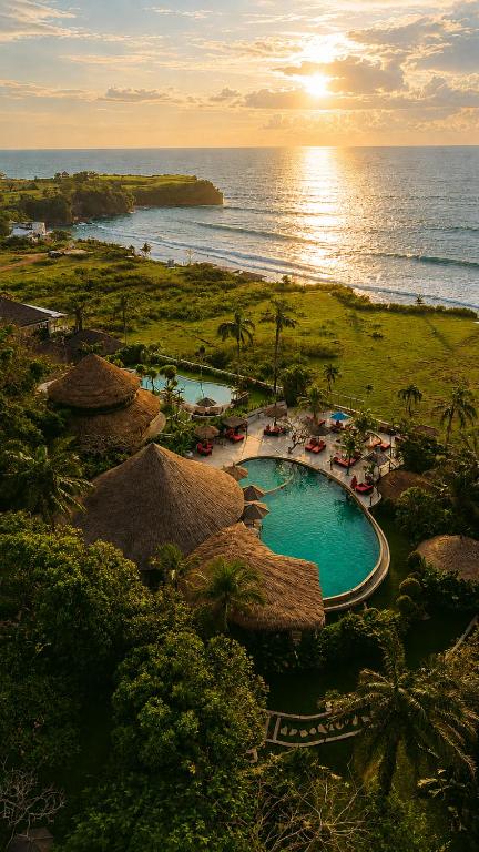 an aerial view of a resort with a pool and the ocean at La Joya Balangan Resort in Jimbaran