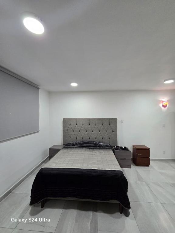 a bedroom with a bed in a white room at Havana House in Mexico City
