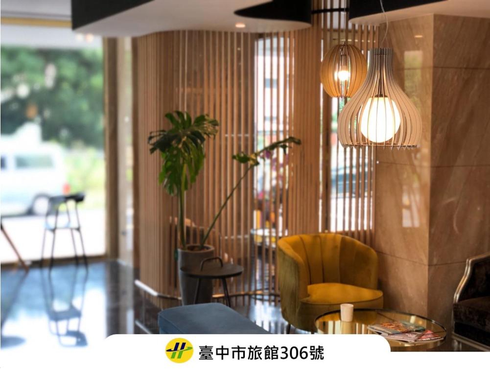 a living room with a yellow chair and a plant at Talmud Hotel Taichung in Taichung
