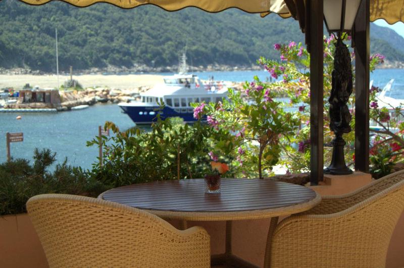 een tafel en stoelen met uitzicht op een haven bij La Calypso in Porto Ota