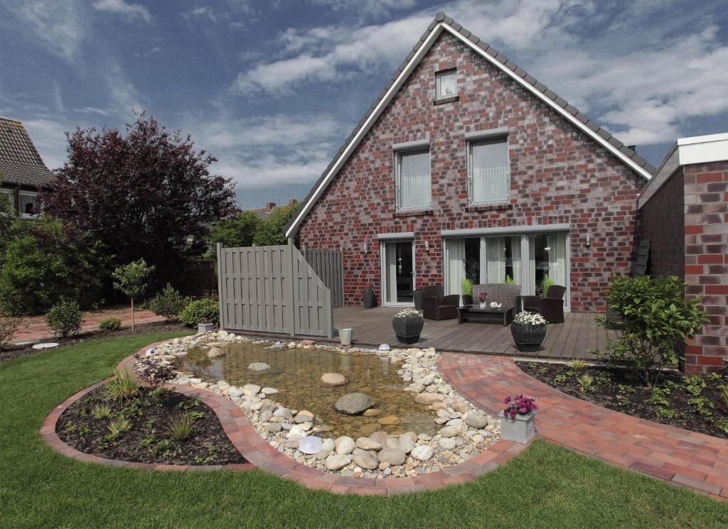 une maison en briques avec un jardin dans la cour avant dans l'établissement Ferienhaus Blinkfuer, à Neuharlingersiel