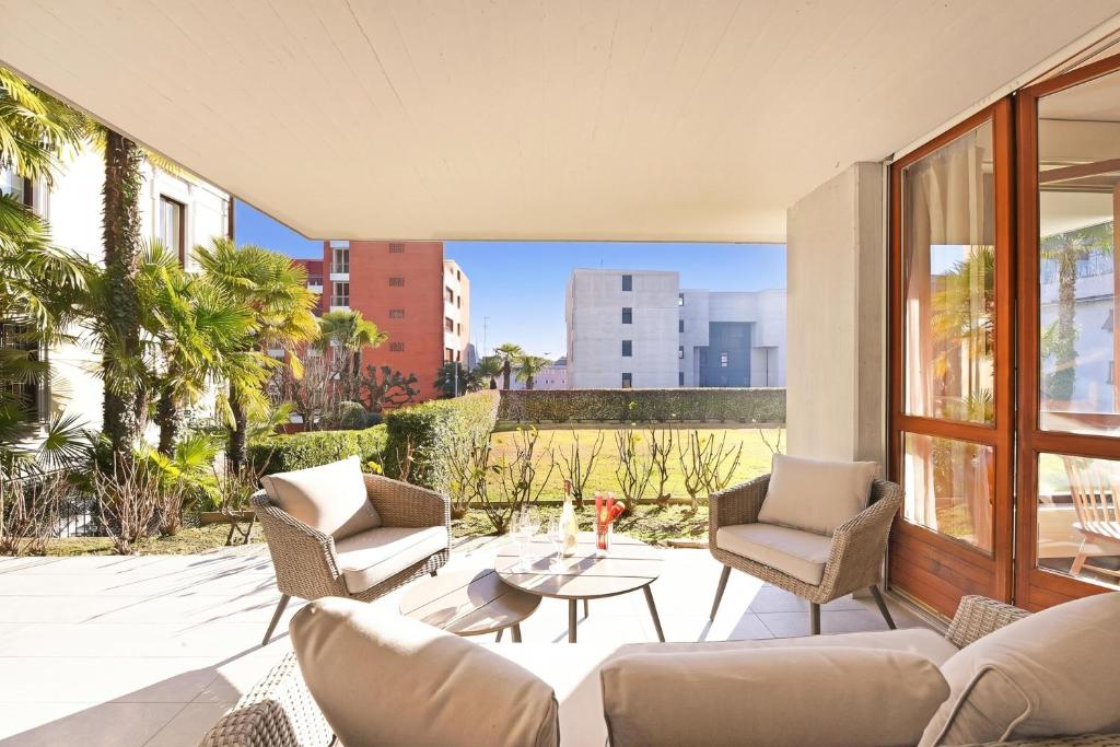 a living room with two chairs and a table at Casa Rinetta with Patio and A/C - Happy Rentals in Lugano