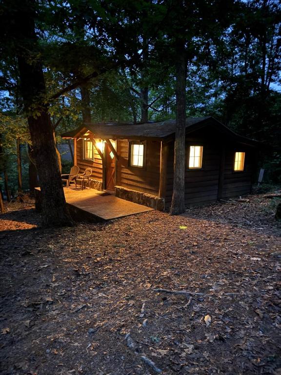 a cabin in the woods with lights on at 4-OH, DEER! - Historic Five Points Lake Hamilton in Hot Springs