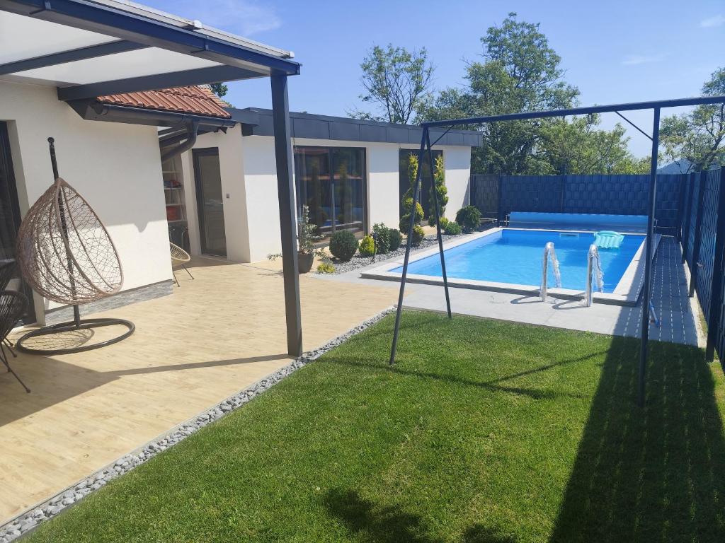 a backyard with a swing and a swimming pool at Počitniška hiša Maja v naravi in Planina pri Sevnici