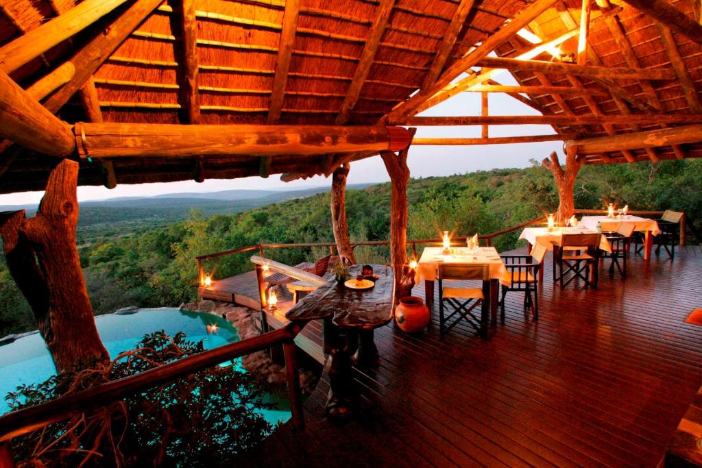 a restaurant with tables and chairs on a deck at Nedile Lodge in Vaalwater