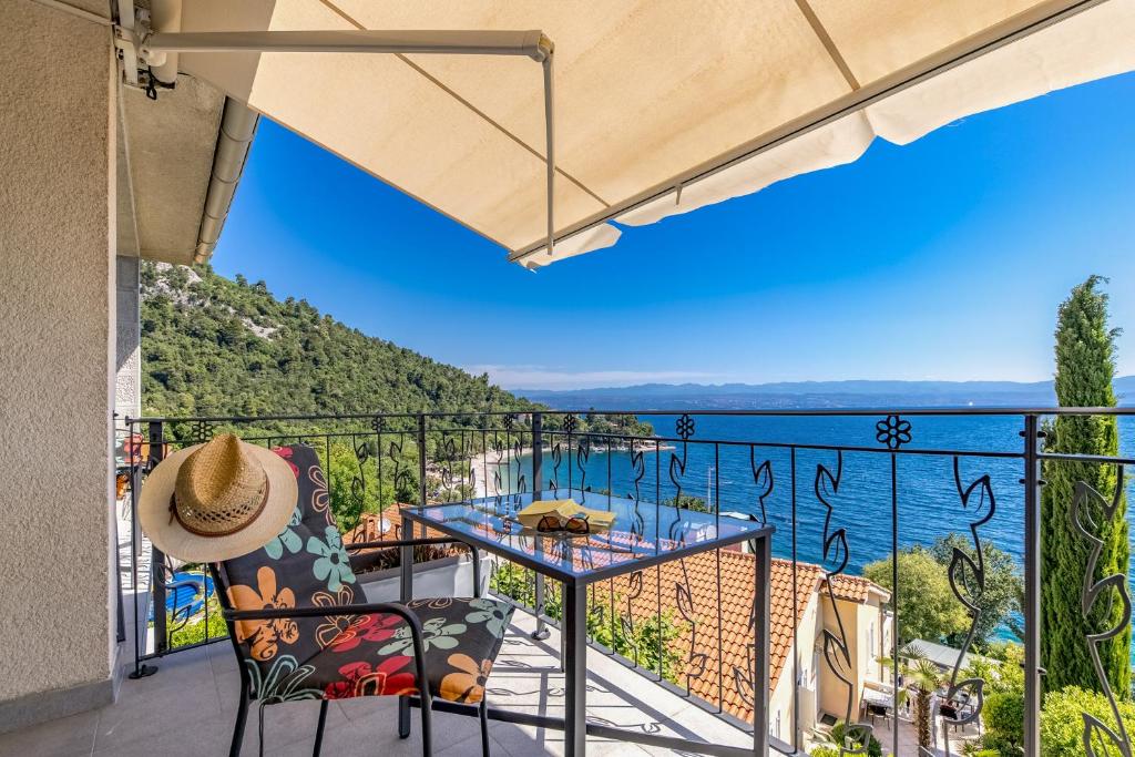 a balcony with a table and chairs and a view of the ocean at Beachside Villa Mia Apartments in Medveja