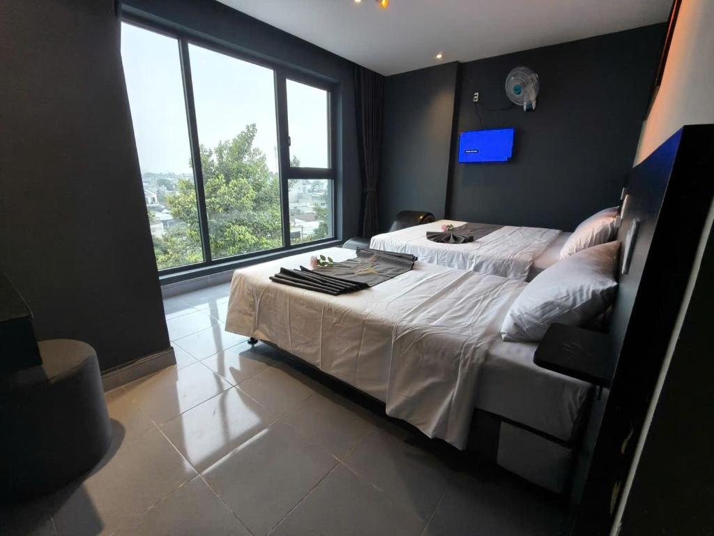 a bedroom with a large bed and a large window at Hoài Thu Luna Hotel in Ðông Hòa