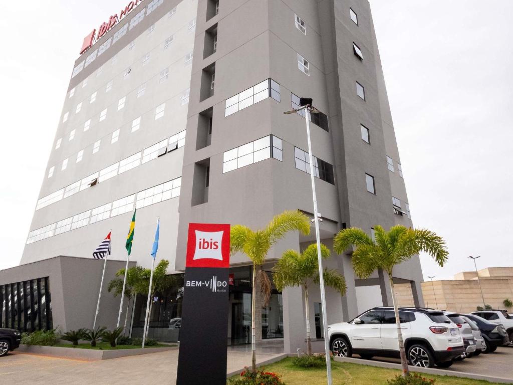 a building with cars parked in front of it at Ibis Votuporanga in Votuporanga