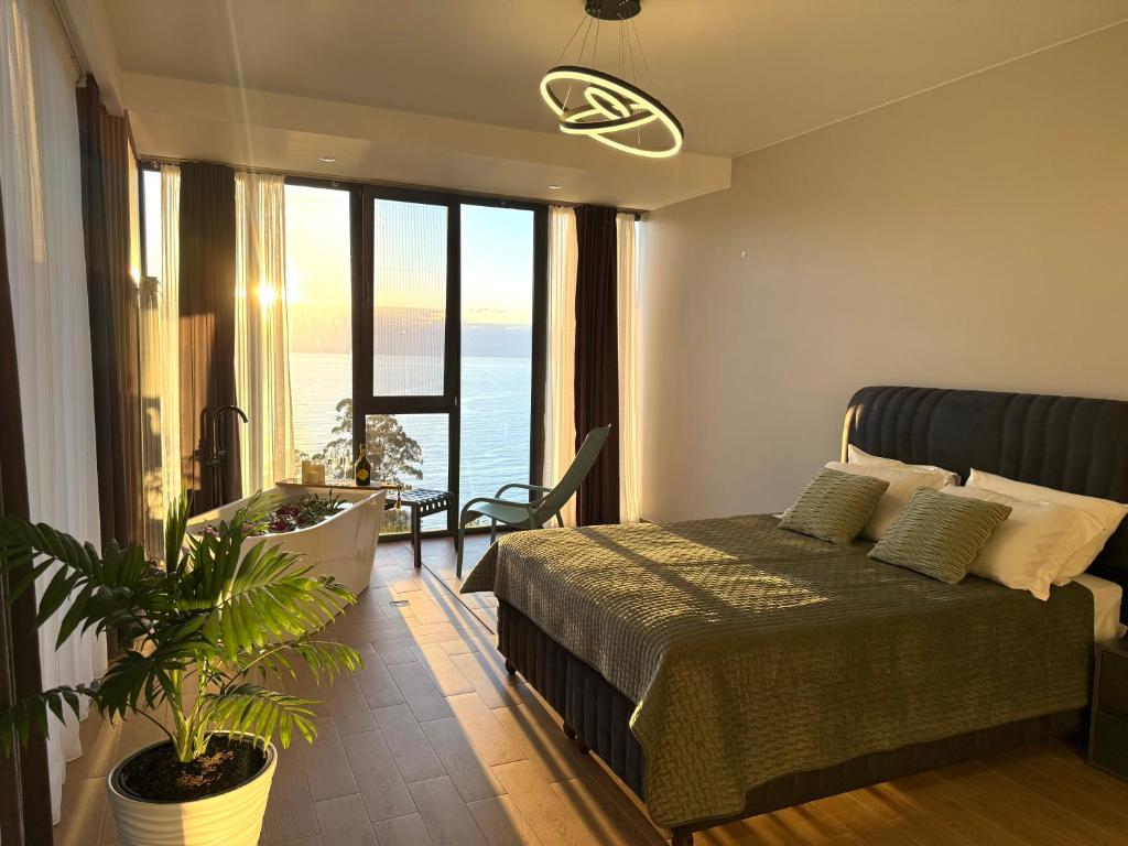a bedroom with a bed and a view of the ocean at Modern Villa - infinity pool & Panoramic Sea View in Kvariati