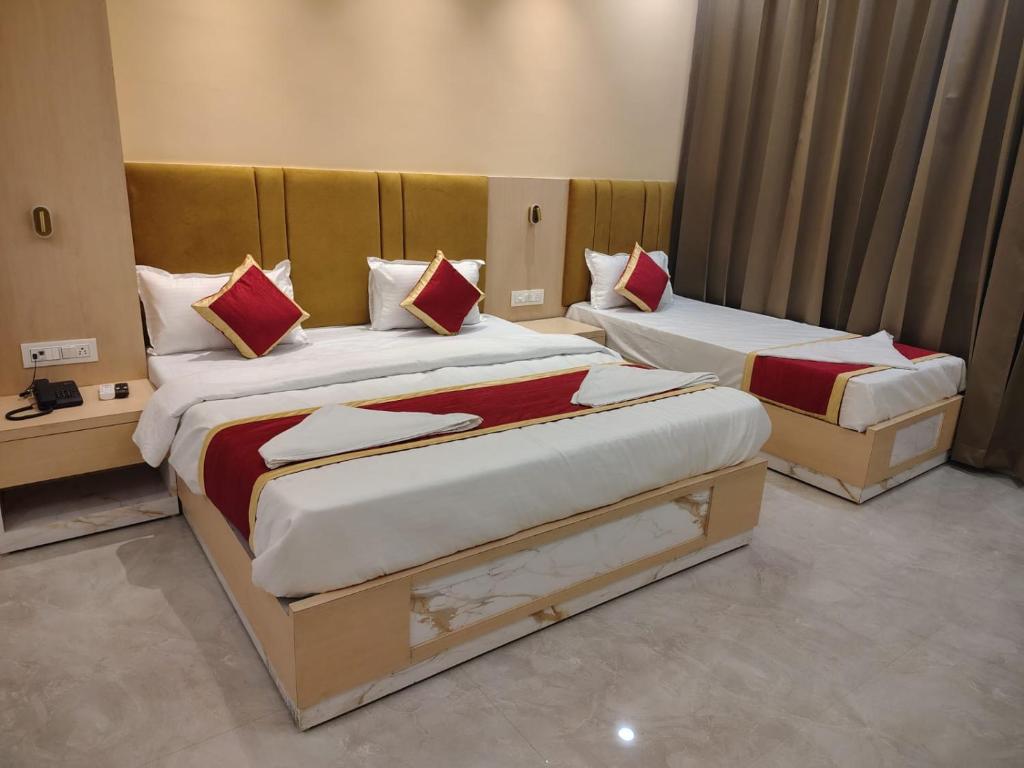 two beds in a hotel room with at Hotel SS Palace in Gaya