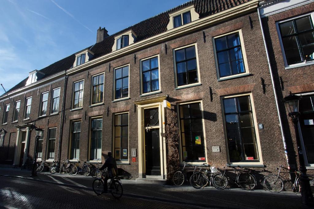 een bakstenen gebouw met buiten geparkeerde fietsen bij Strowis Hostel in Utrecht