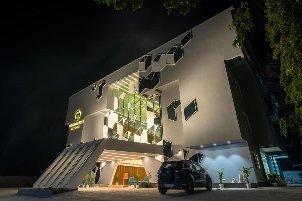 a scooter parked in front of a building at night at Clubway Grand A Boutique Hotel Jorhat in Jorhāt