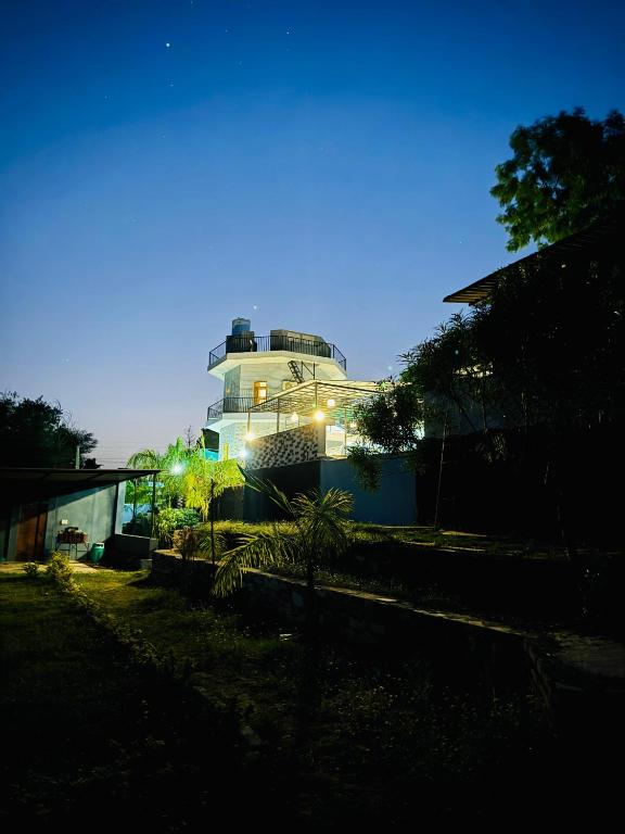 a large building with lights on it at night at Kevda Crown Estate in Keora