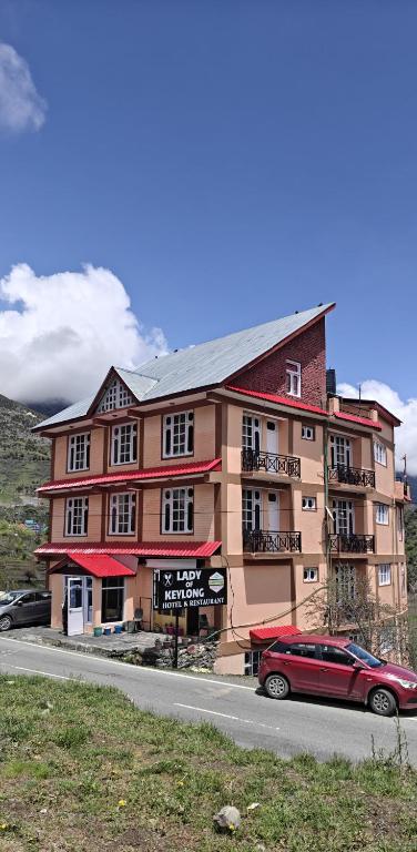 a red car parked in front of a building at Hotel Lady of Keylong in Kyelang