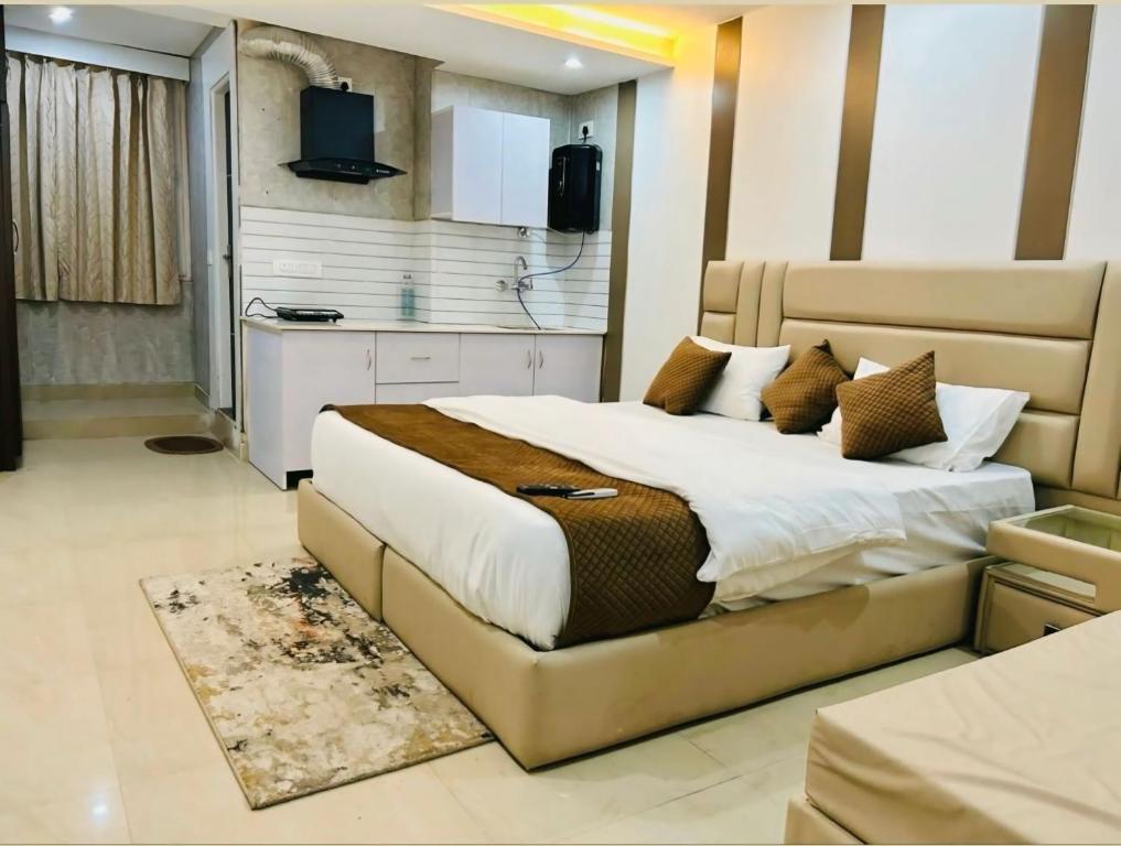 a bedroom with a large bed and a kitchen at The Sandstone Studio in Dehradun