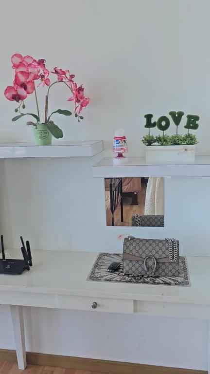a white desk with flowers in a vase on it at Swiss belhotel apartment in Kuantan