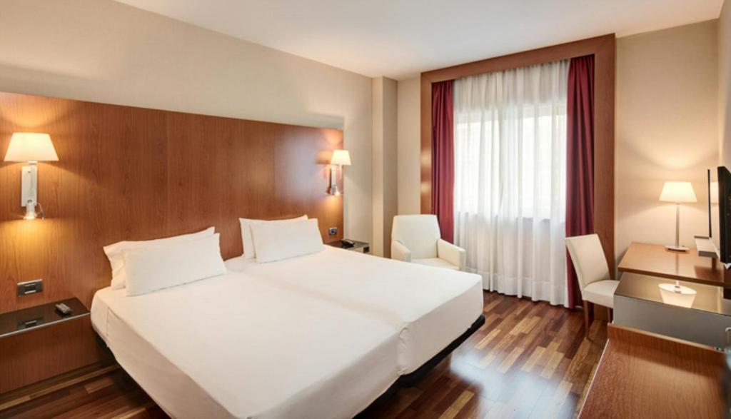 a large white bed in a hotel room at Sercotel AB Arganda in Arganda del Rey