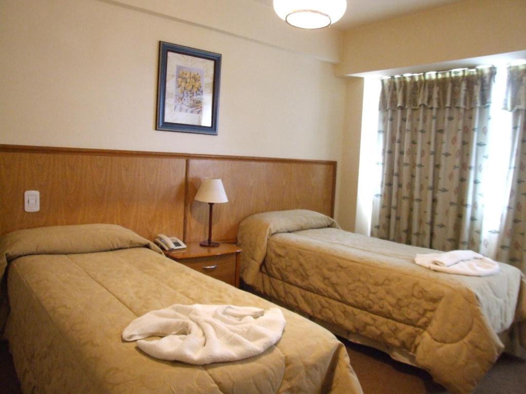 a hotel room with two beds and a phone at Hotel Internacional in San Carlos de Bariloche