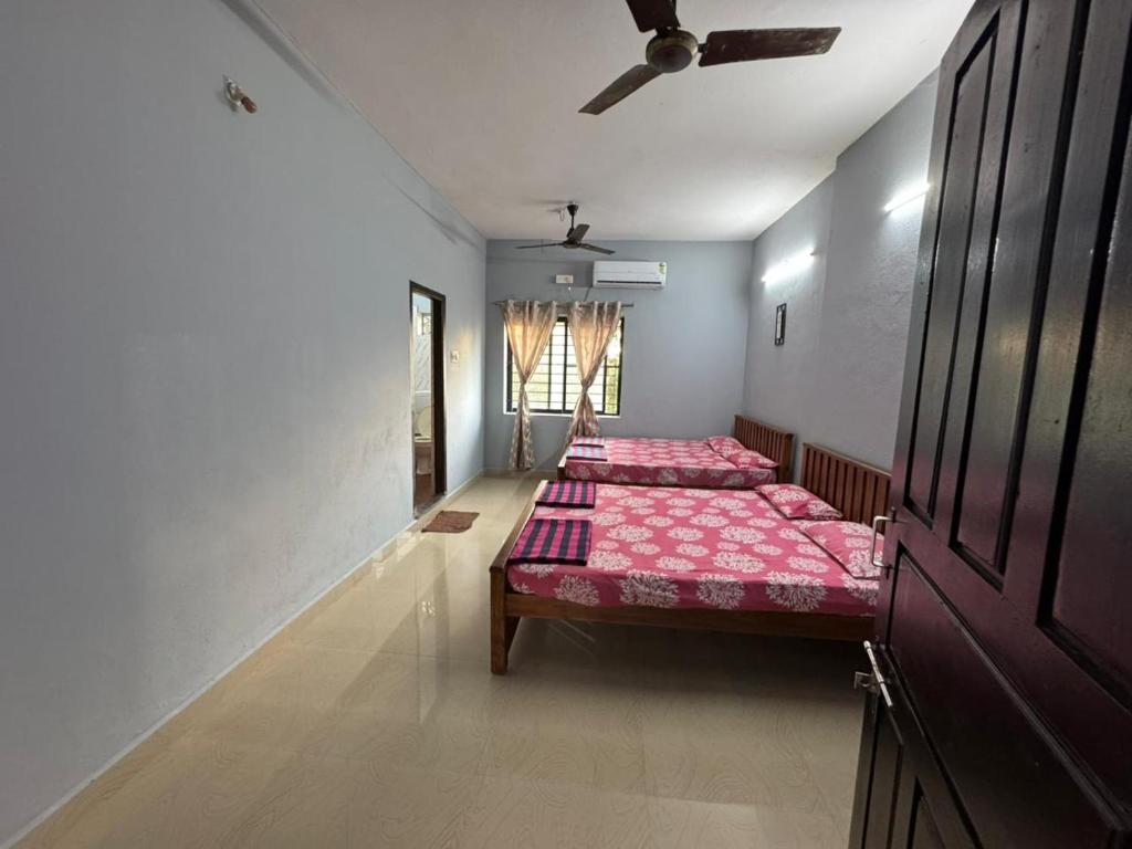 a bedroom with two beds and a ceiling at Kenson Retreat in Mangalore