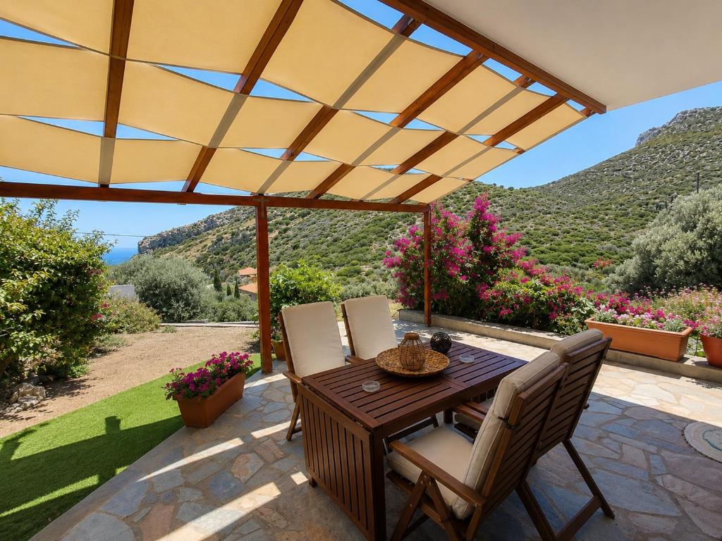 a wooden table and chairs on a patio with mountains at Emma's HOUSE near beach in Tsakaíoi
