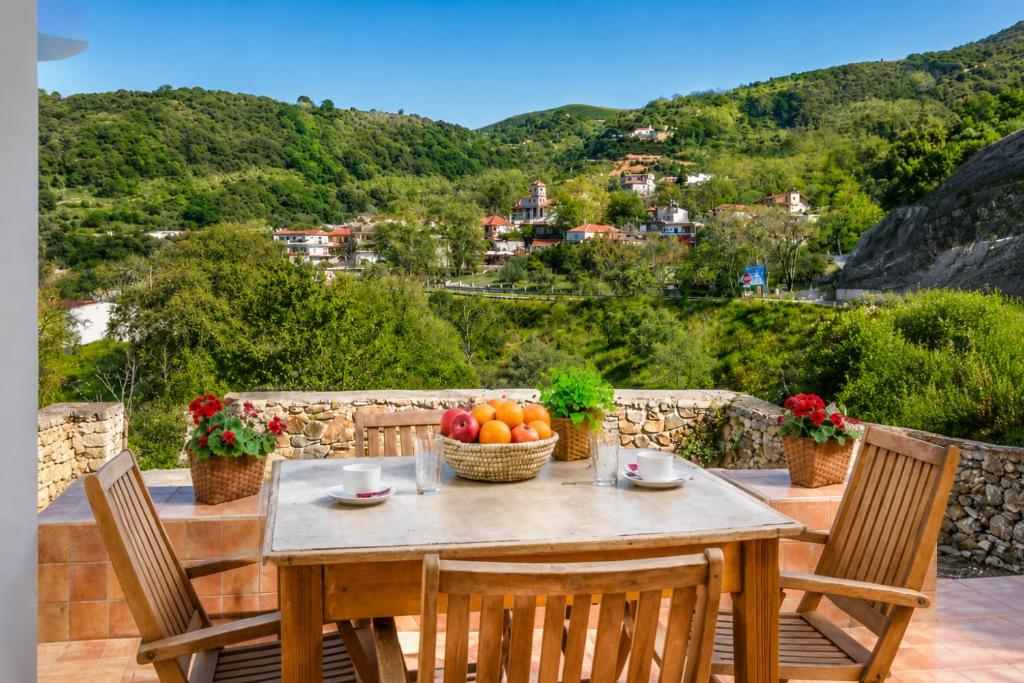a table with a bowl of fruit on a balcony at Pandora Stone Cottage Elos in Élos
