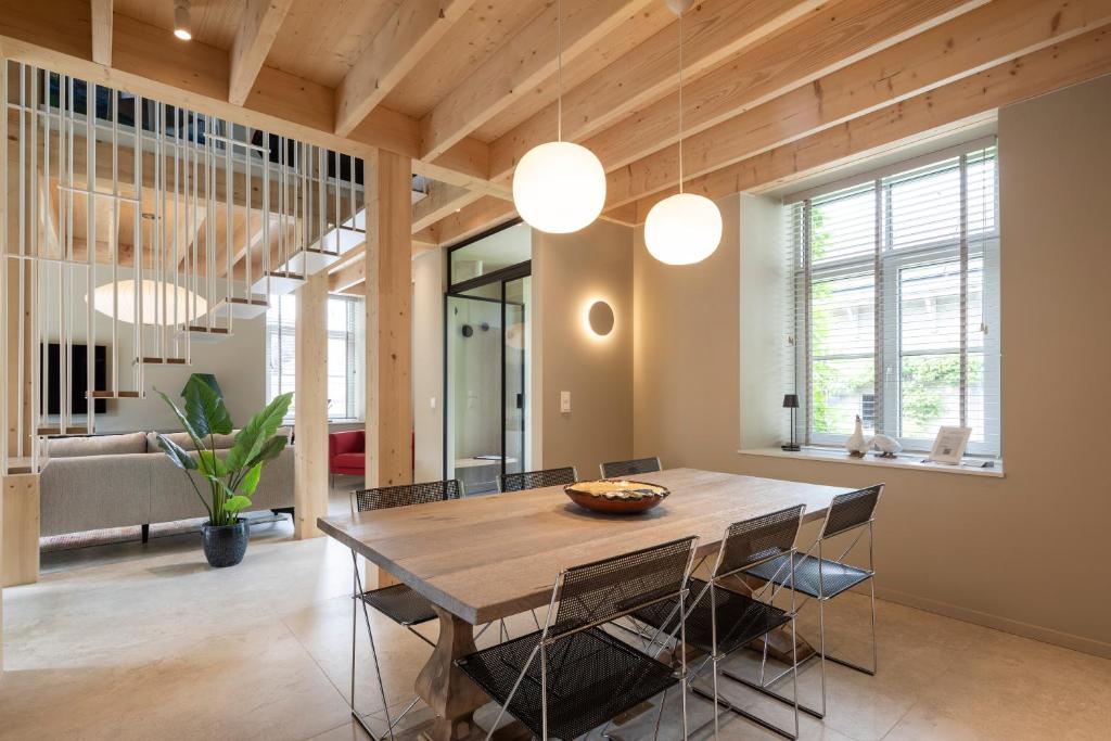 a dining room with a wooden table and chairs at Entre Pierres et Rivière - 2 Gites avec wellness privatifs in Hotton