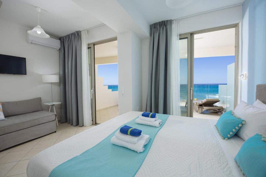 a bedroom with a large bed with towels on it at SEPERI Deep Blue in Rethymno
