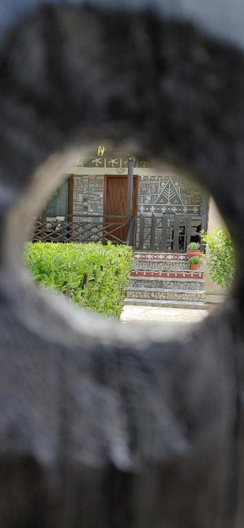 a view of a building through a porthole in a building at Marathon Βeach Ηouse in Panayía Mesosporítissa